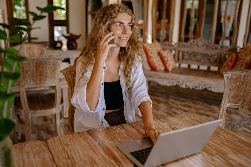 astrologue au téléphone dans son salon et avec son ordinateur devant elle