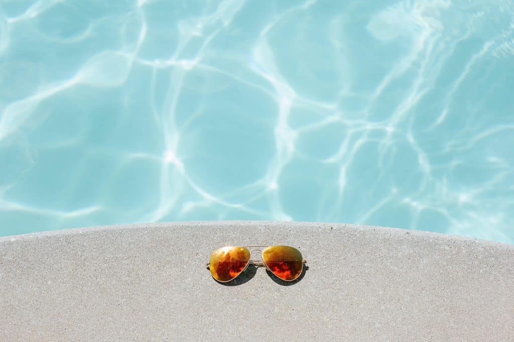 lunettes de soleil devant l'eau d'une piscine