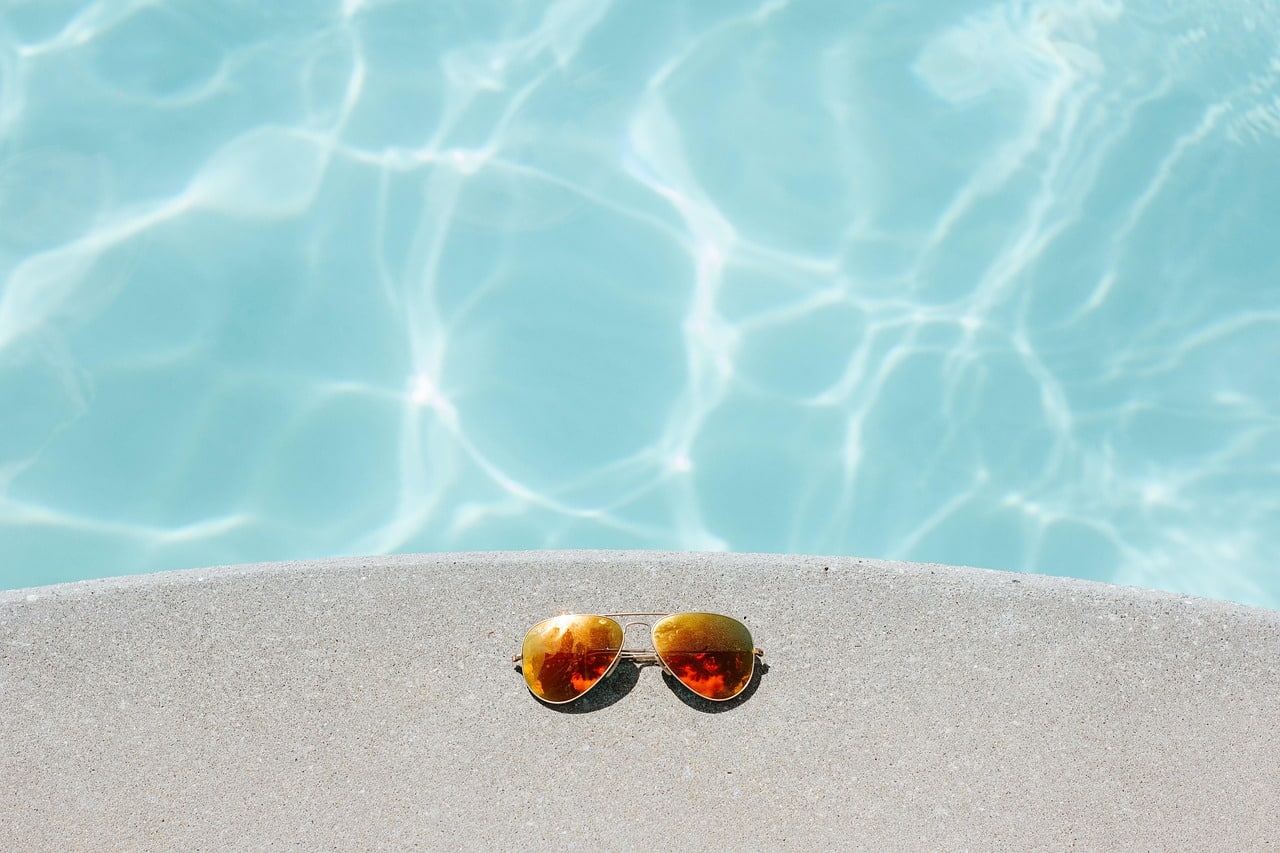 lunettes de soleil devant l'eau d'une piscine